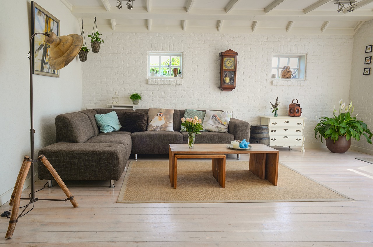 A living room with a grey sofa, a wooden coffee table and potted plants